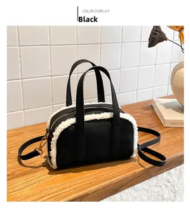 Detail of black canvas and white faux shearling tote bag with metal hardware on display