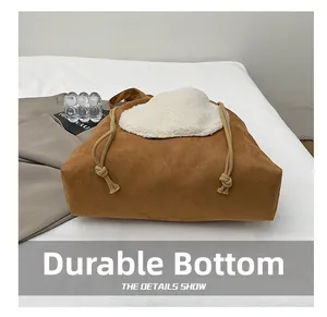 Detail view of durable bottom on a brown suede tote bag with white fleece heart design