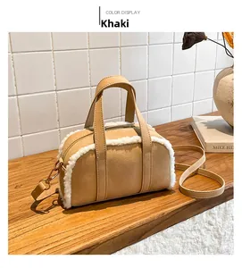 Detail of khaki faux suede bowling bag with white fleece trim on a wooden tabletop