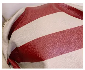 Macro shot of red and white striped lychee grain leather on a vintage shoulder bag