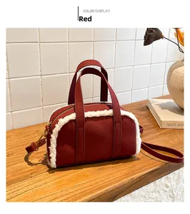 Detail of retro red suede crossbody bag with white faux shearling trim and gold hardware