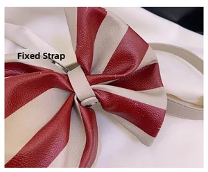 Close-up of red and beige striped leather bow detail with litchi grain texture