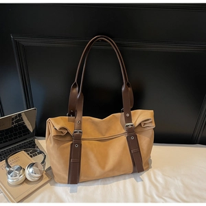 Macro shot of khaki tote bag with adjustable leather straps and metallic buckle detail