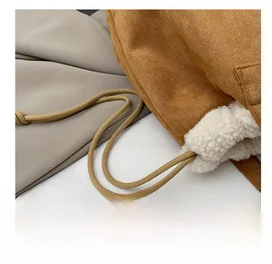 Detail shot of brown suede bucket bag with white fleece lining and drawstring cord