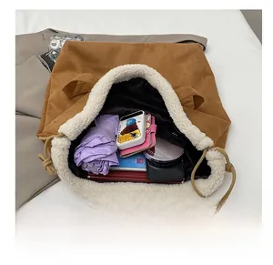 Top view of spacious brown suede tote bag with white faux shearling trim and daily essentials