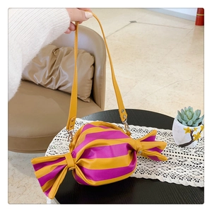 Detail showing candy-shaped handbag with yellow and purple stripes and side bow knots