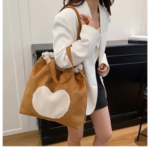 Detail of vintage brown tote bag with white plush heart patch and fleece trim