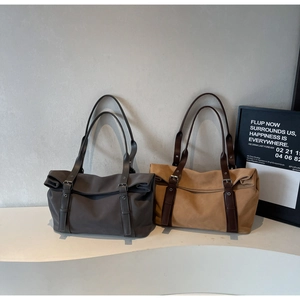 Detail of large commute tote bags in dark grey and khaki with decorative metal buckle straps