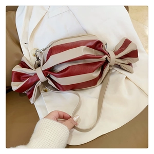 Macro view of candy-shaped crossbody bag featuring red and beige striped leather texture