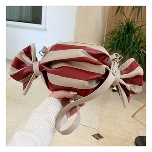 Detail of candy-shaped shoulder bag with red stripes and textured synthetic leather