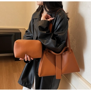 Detailed close-up of brown lychee pattern leather shoulder bag and matching zipper clutch set