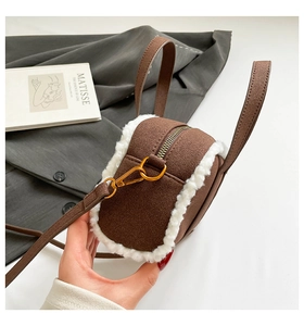 Detail of brown plush bowling bag with white faux fur trim and gold metal zipper hardware