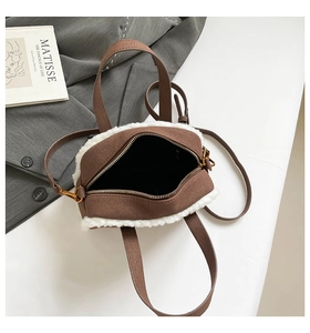 Detail of winter crossbody bag with brown suede and white faux fur trim on a table