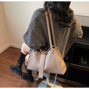 Detailed view of beige leather tote bag with vertical stripes and dual shoulder straps