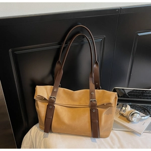 Detail of vintage mustard tote bag with buckle straps and textured matte finish