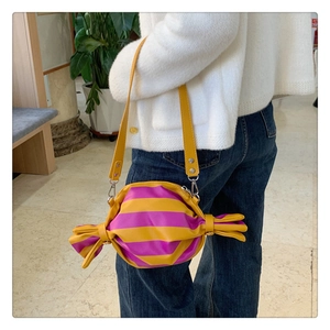 Close-up of candy-shaped crossbody bag with vibrant yellow and purple stripes