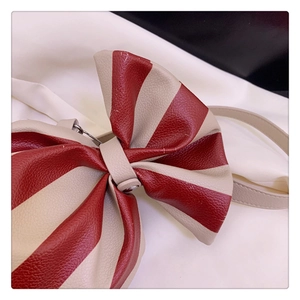 Detail shot of the red and white candy cane striped bow bag showing litchi leather texture