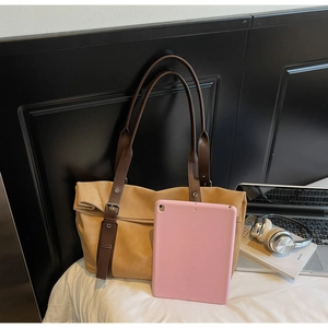 Detailed view of a khaki tote bag showing its large capacity for tablets and books