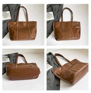 Detail view of large brown faux leather tote bag with silver metal rivet accents and straps