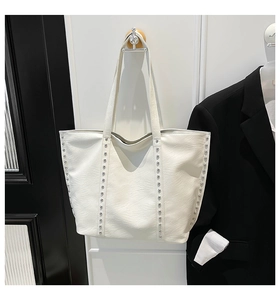 Close-up of white tote bag with silver studs and high-quality synthetic leather texture