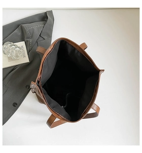 Detail view of large brown faux leather tote bag with spacious interior and zipper closure