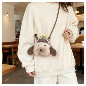 Détail du sac à bandoulière en peluche chien teddy avec fermoir en métal et pompons jaunes