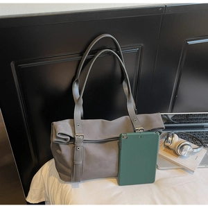 Detailed view of gray matte leather tote bag with silver buckle and spacious interior