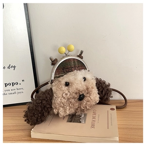 Gros plan d'un sac bandoulière chiot en peluche avec fermoir en métal sur table en bois