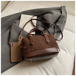 Détail du sac à bandoulière en peluche marron avec garniture en cuir et métal doré