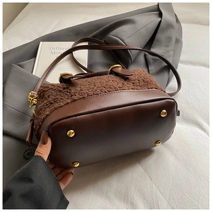 Détail du sac à main en laine d'agneau et cuir marron avec clous de protection dorés