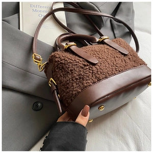 Détail du sac à main en peluche marron foncé avec garniture en cuir et pieds dorés