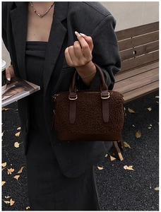 Détail du sac à main en peluche marron avec finitions cuir et anneaux dorés