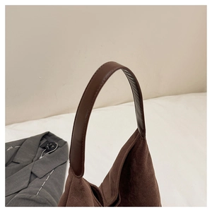 Detailed view of vintage matte brown shoulder bag showing handle stitching and texture