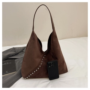 Detail of dark brown suede hobo bag with silver rivets and smooth shoulder strap texture