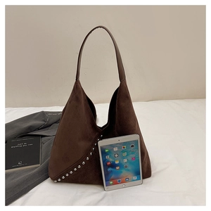 Detail of dark brown suede shoulder bag with silver rivet studs and spacious design