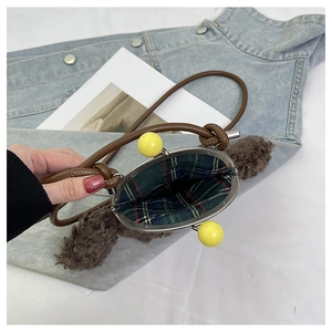Vue détaillée du sac en peluche marron avec doublure à carreaux et fermoir à billes