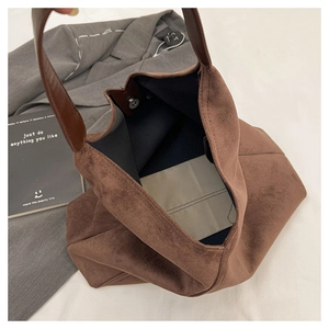 Detail view of large brown suede hobo bag interior with magnetic closure and inner pouch