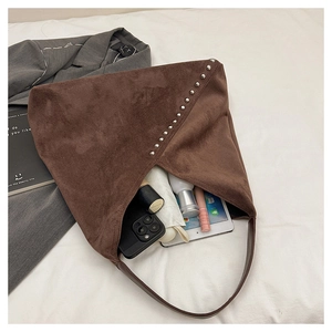 Detail of spacious interior storage in brown suede shoulder bag with metallic rivets