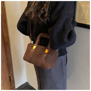 Detail of plush faux shearling Boston bag with leather handles and gold metal hardware