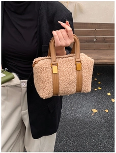 Detail of light camel sherpa Boston bag with brown leather handles and gold lock
