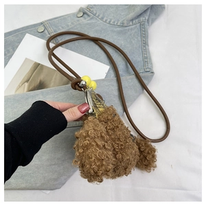 Gros plan du sac chiot en peluche marron avec fermoir métallique et billes jaunes