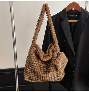 Detail of brown faux fur tote with checkered pattern and matching coin purse charm
