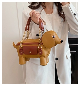 Close-up of dachshund bag detail with brown leather pocket and gold metal snap fastener
