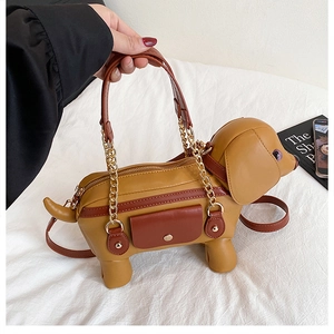 Detail of dachshund puppy shape handbag with ginger PU leather and gold chain strap
