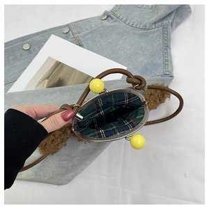 Détail du sac bandoulière en peluche marron avec fermoir à boules jaunes et doublure