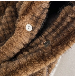 Close-up of fluffy brown plush texture and silver metal magnetic buckles on a tote bag