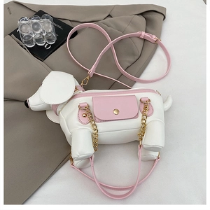 Detail of cute puppy-shaped crossbody bag featuring pink pocket and gold chain strap