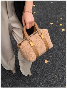Detailed close-up of beige fleece Boston bag with brown leather trim and gold hardware
