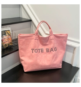 Detailed macro view of pink PU leather tote bag with stylish metallic stud lettering