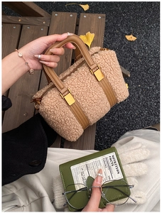 Detailed close-up of plush Boston bag with leather handles and gold metal hardware links